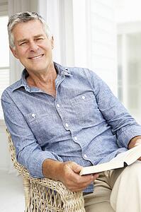 Senior man relaxing at home with a book
