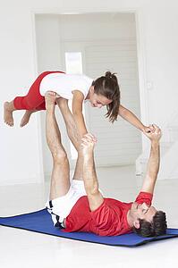 Father and daughter doing yoga lift