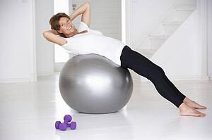 Senior woman using gym ball