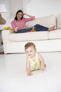 Mother watching baby crawl