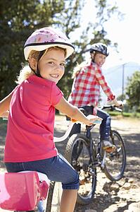 Little girl on country bike ride with mom