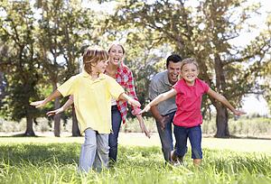 Parents playing with children in country