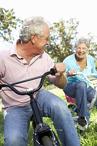 Senior couple playing on children's bikes