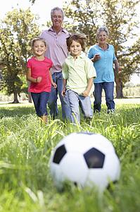 Grandparents playing football with grandchilderen