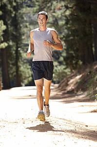 Young man running along country lane