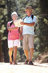 Senior couple reading map on country walk
