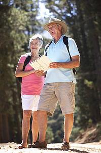 Senior couple reading map on country walk