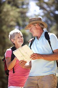 Senior couple reading map on country walk