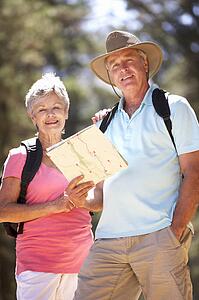 Senior couple reading map on country walk