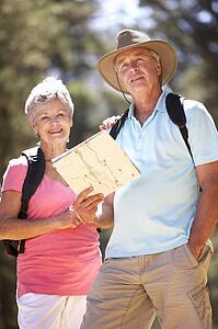 Senior couple reading map on country walk