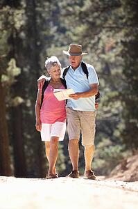 Senior couple reading map on country walk