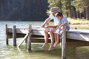 Senior man fishing with grandson