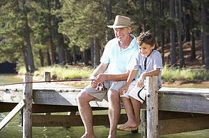 Senior man fishing with grandson