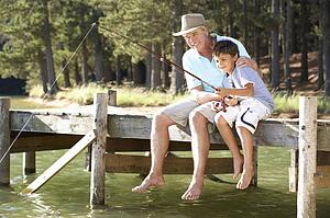 Senior man fishing with grandson