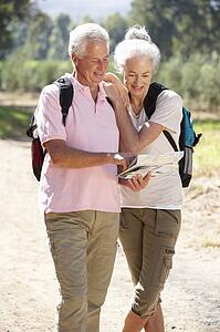 Senior couple reading map on country walk