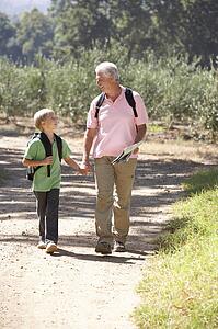 Senior man and grandson on country walk