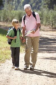 Senior man and grandson on country walk