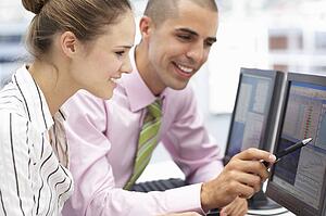 Businessman and woman working on computers