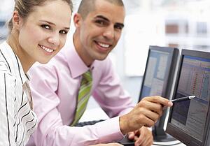 Businessman and woman working on computers