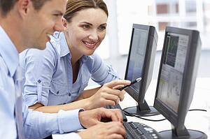 Businessman and woman working on computers