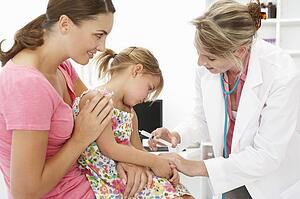 Female doctor injecting child