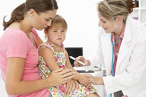 Female doctor injecting child