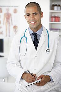Young male doctor writing prescription