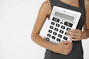 Young businesswoman with giant calculator