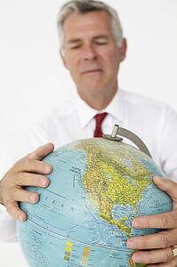 Senior businessman holding globe