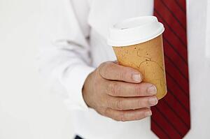 Businessman holding takeout coffee