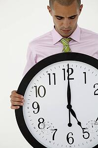 Young businessman with giant clock