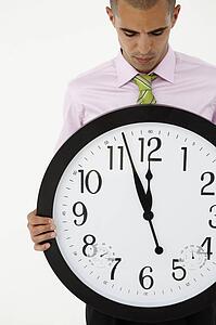 Young businessman with giant clock