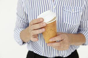 Businesswoman holding takeout coffee