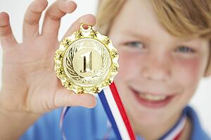 Young boy showing off medal