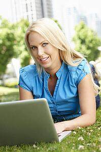 Woman using laptop in city park