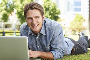 Man using laptop in city park