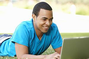Young man using laptop outdoors