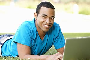 Young man using laptop outdoors