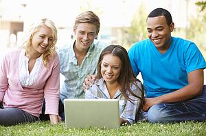 Young people using laptop outdoors