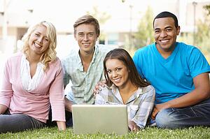 Young people using laptop outdoors