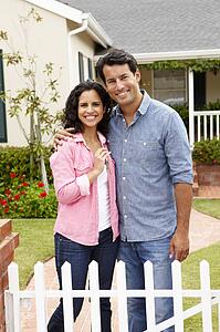 Hispanic couple outside new home