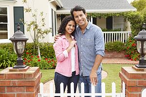 Hispanic couple outside new home