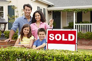 Hispanic family outside home with sold sign