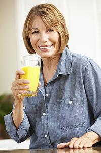 Mid age woman drinking orange juice