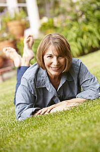 Mid age woman relaxing in garden