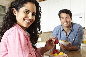 Hispanic couple eating cereal and fruit