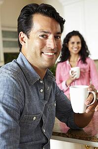 Hispanic couple relaxing in kitchen
