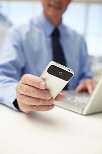 Senior businessman with laptop and phone