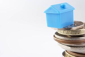 Small model house and coins