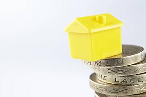 Small model house and coins